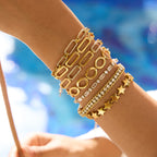 Gleam Bracelet in gold worn in a mixed jewellery stack