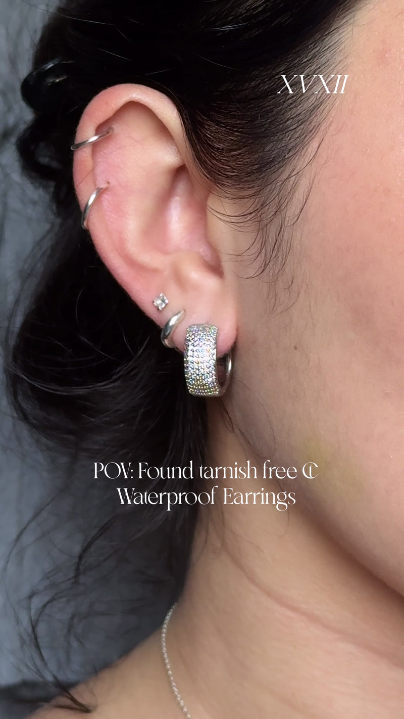 Cassandra Png wearing Flicker Hoops in Silver, Milky Way Hoops in Silver, and Climber Studs.