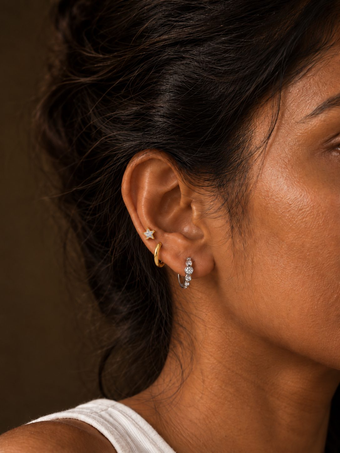 Star Studs in gold worn on ear with silver Orla earrings and a gold Basic hoop