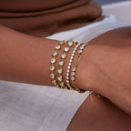 Thin Tennis Bracelet in gold worn in a wrist stack