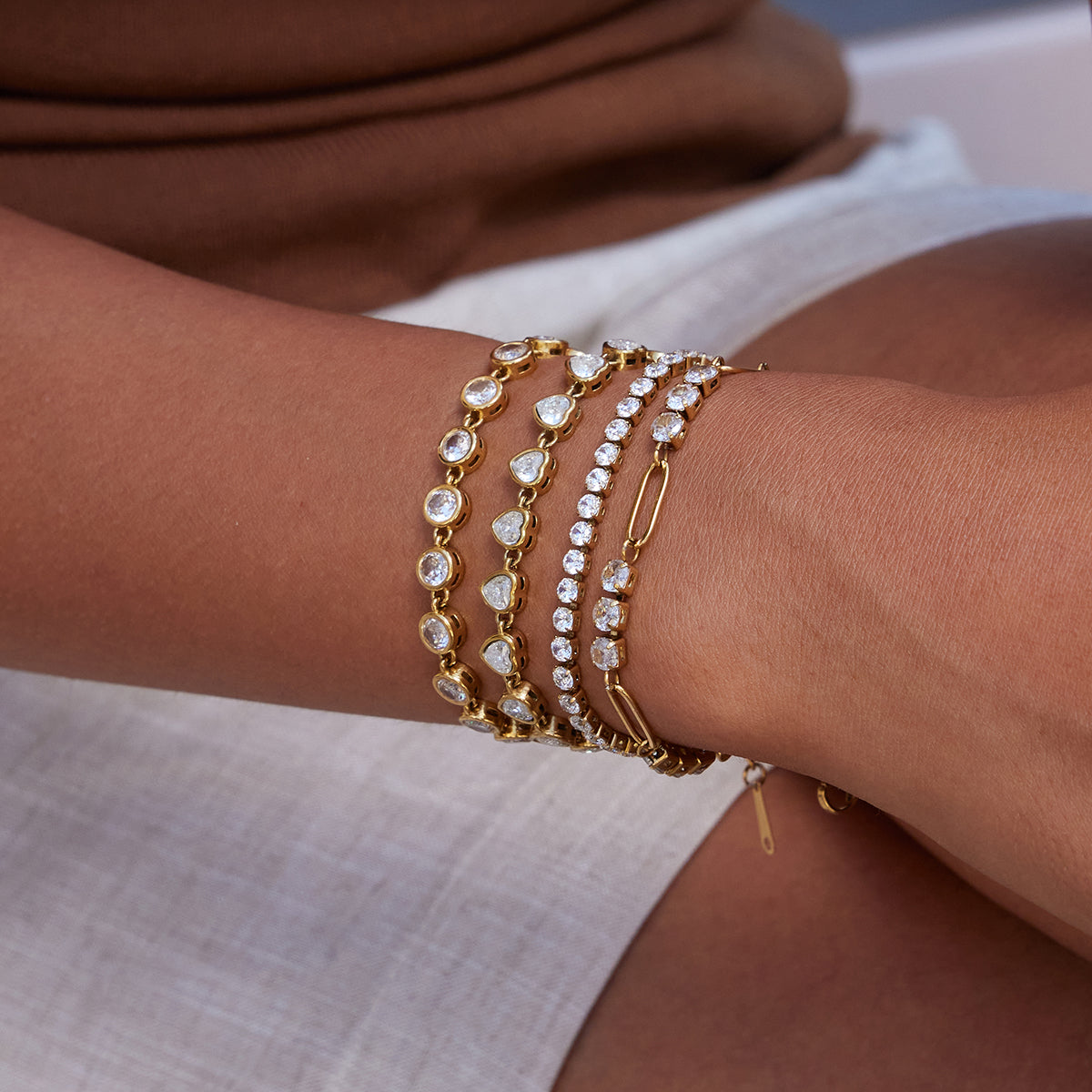 Thin Tennis Bracelet in gold worn in a wrist stack